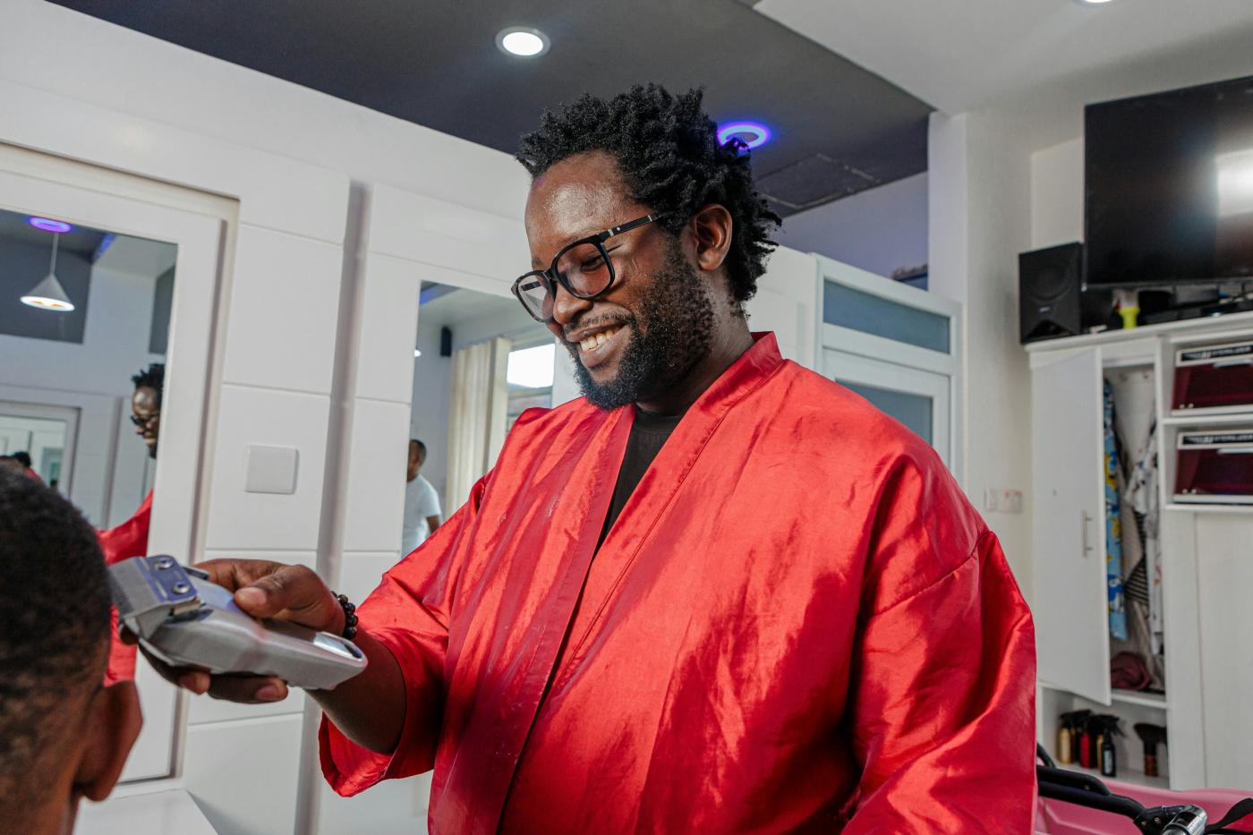 A smiling barber at work in a bright salon